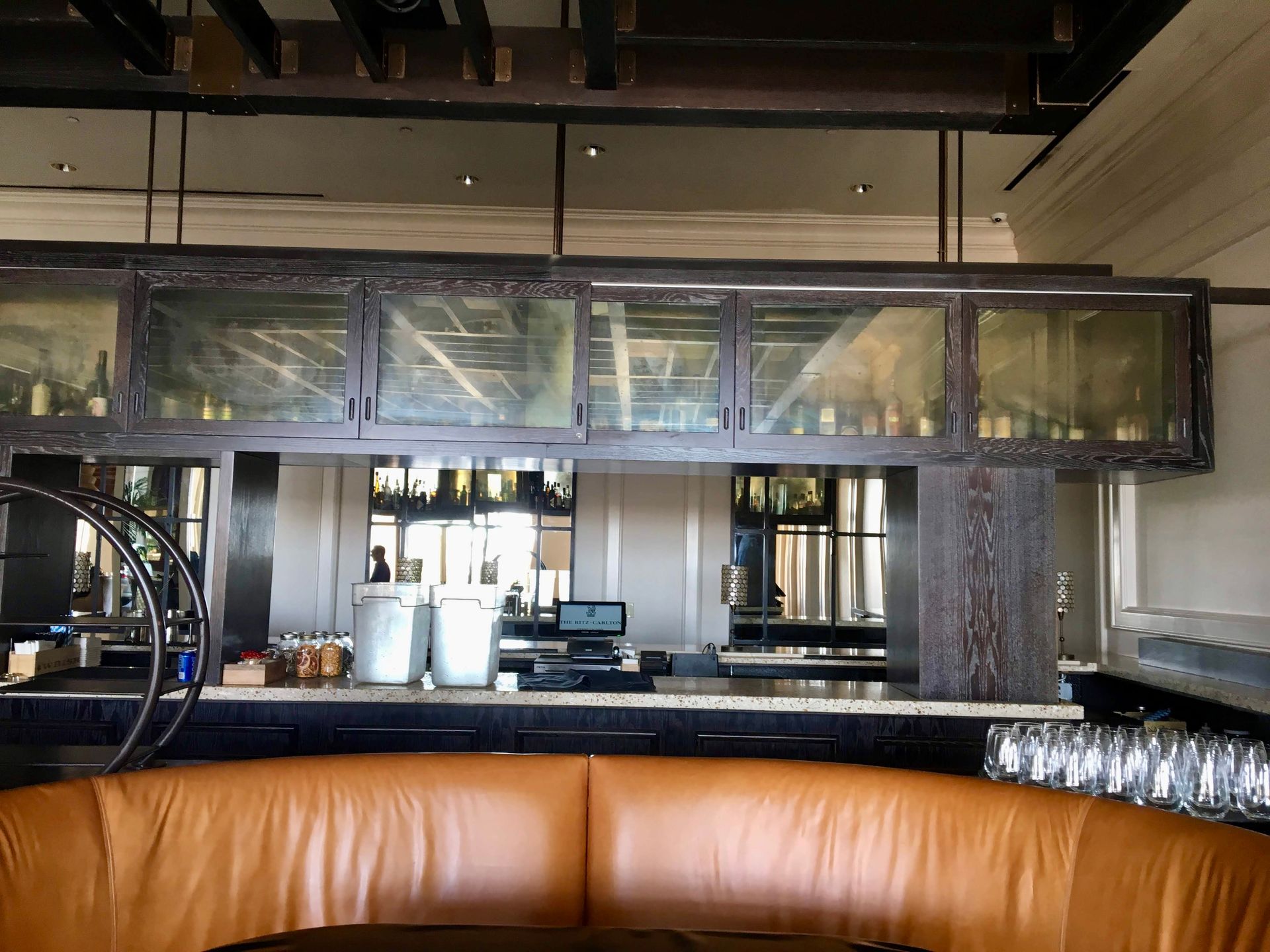 A restaurant with a brown leather couch and a bar