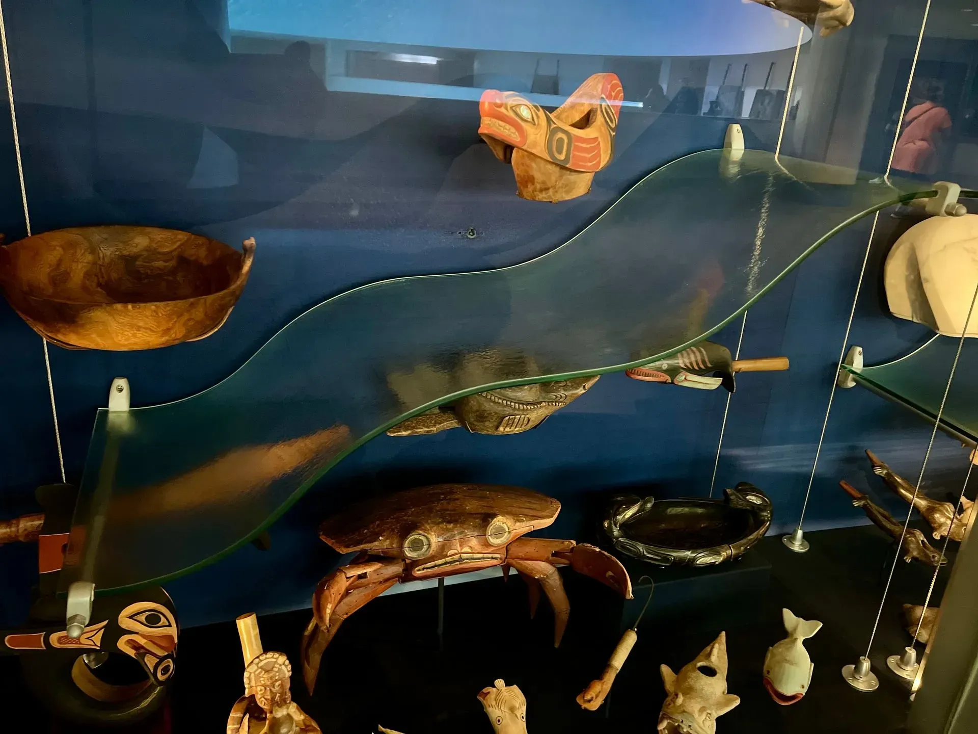 A display case with a crab on top of a glass shelf