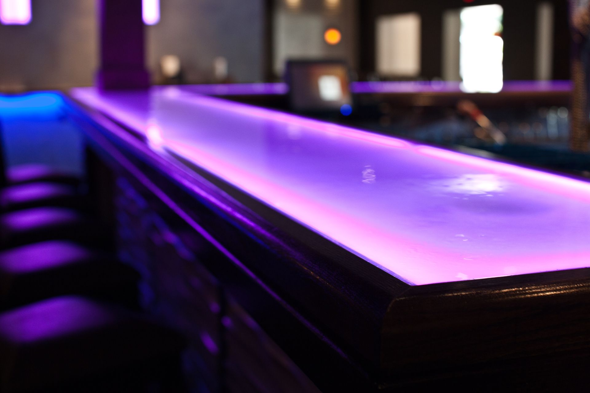 A glass countertop with integrated LED lights glowing purple.