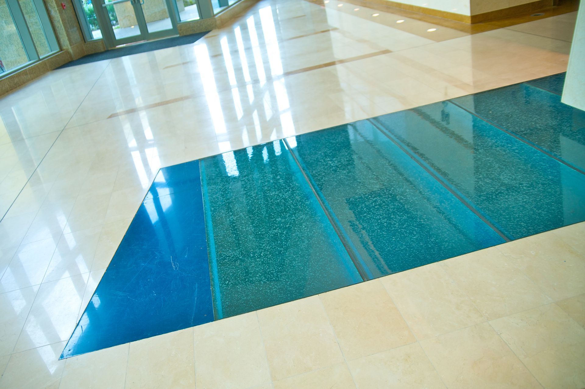 Blue and green glass flooring incorporated into a tile floor.
