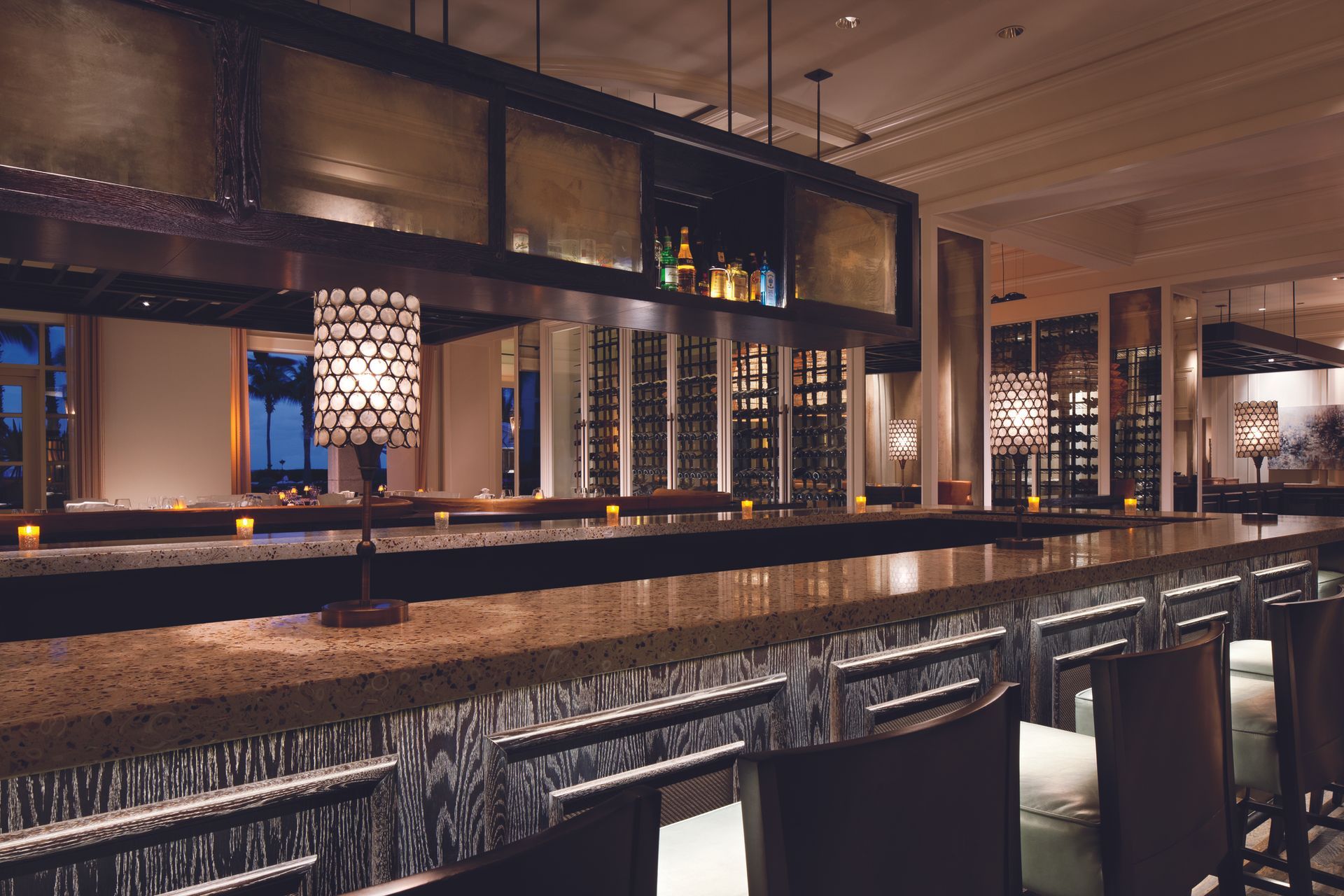 A long bar in a restaurant with a lot of glasses on it