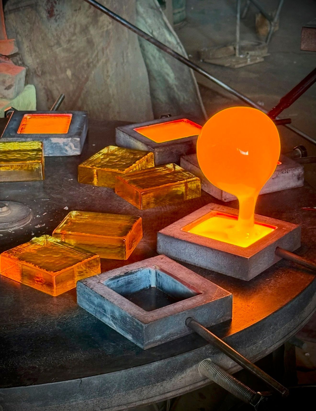Molten glass being poured into square molds during the casting process at TCG Glass