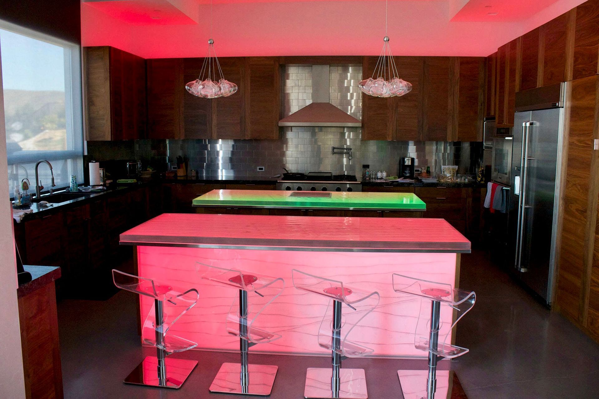 A kitchen with a pink island and stools
