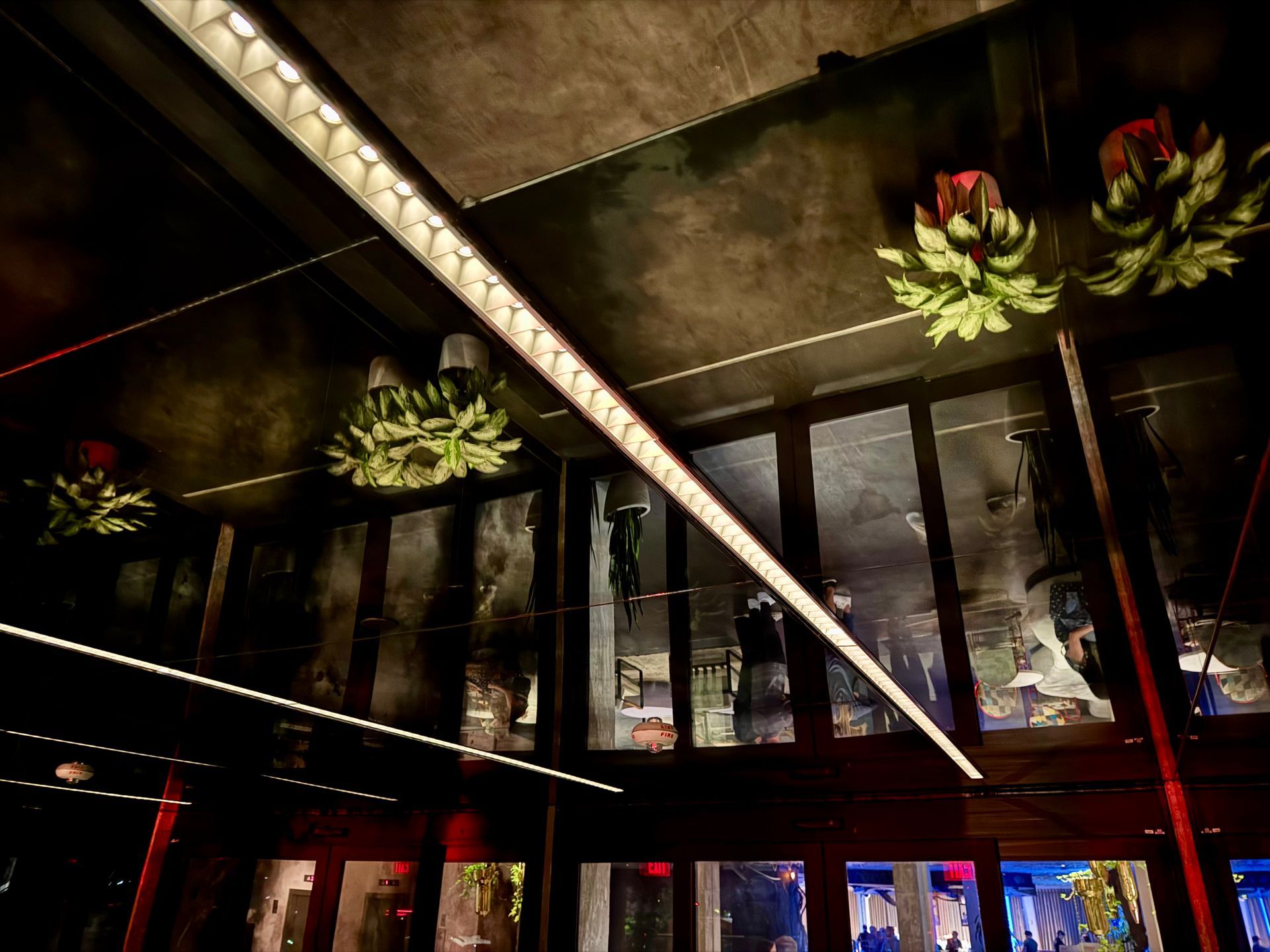 A dark room with a lot of windows and lights on the ceiling