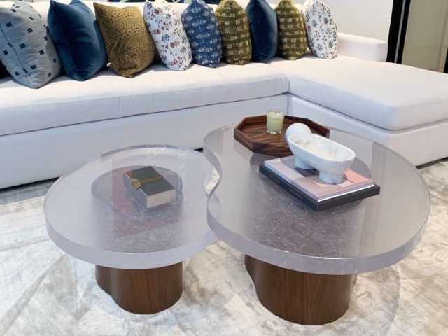 A living room with a couch and two coffee tables with glass table tops