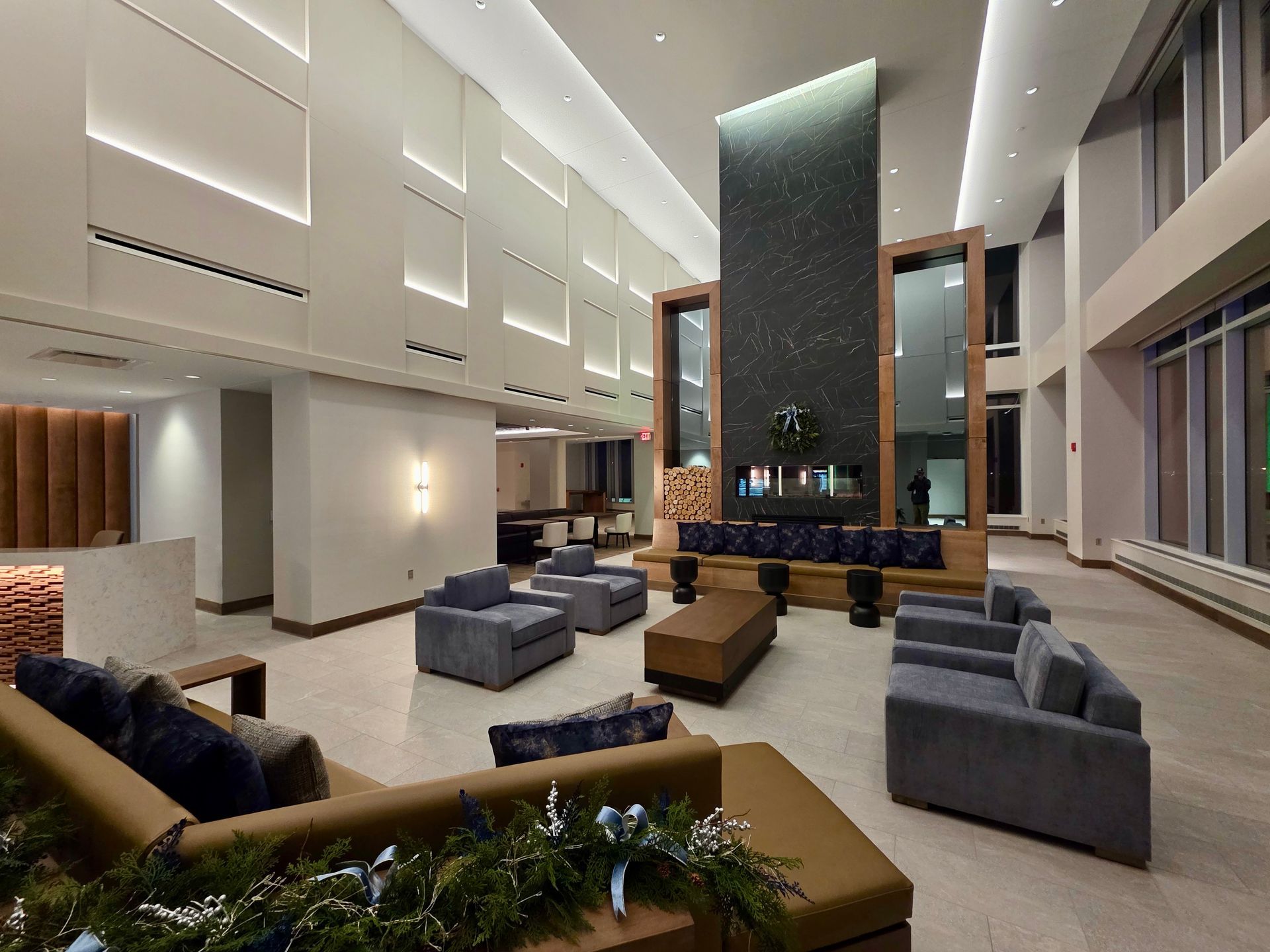 Lounge area with modern decor: couches, fireplace, and ambient lighting.