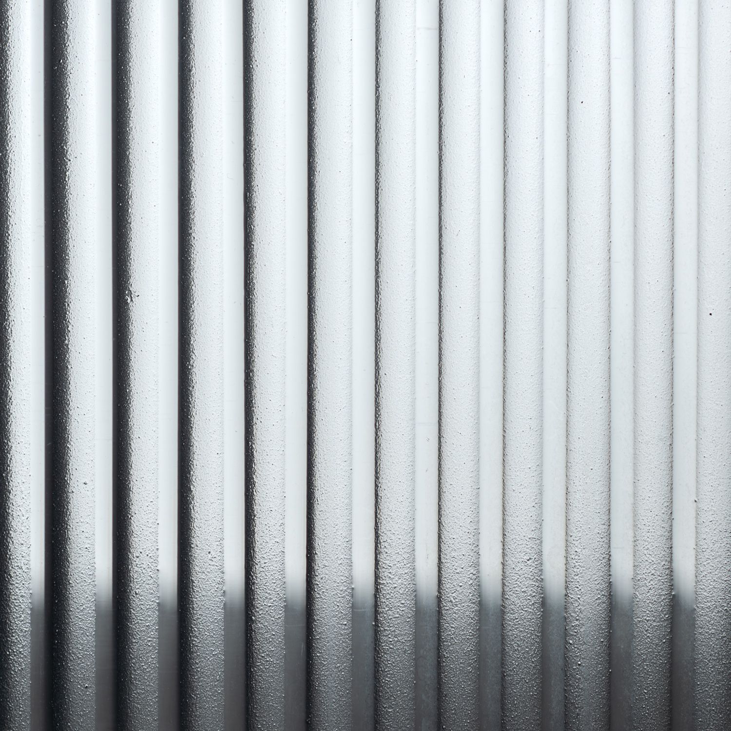 A pattern of vertical, textured metallic ribs creating a gradient from light grey to dark grey.