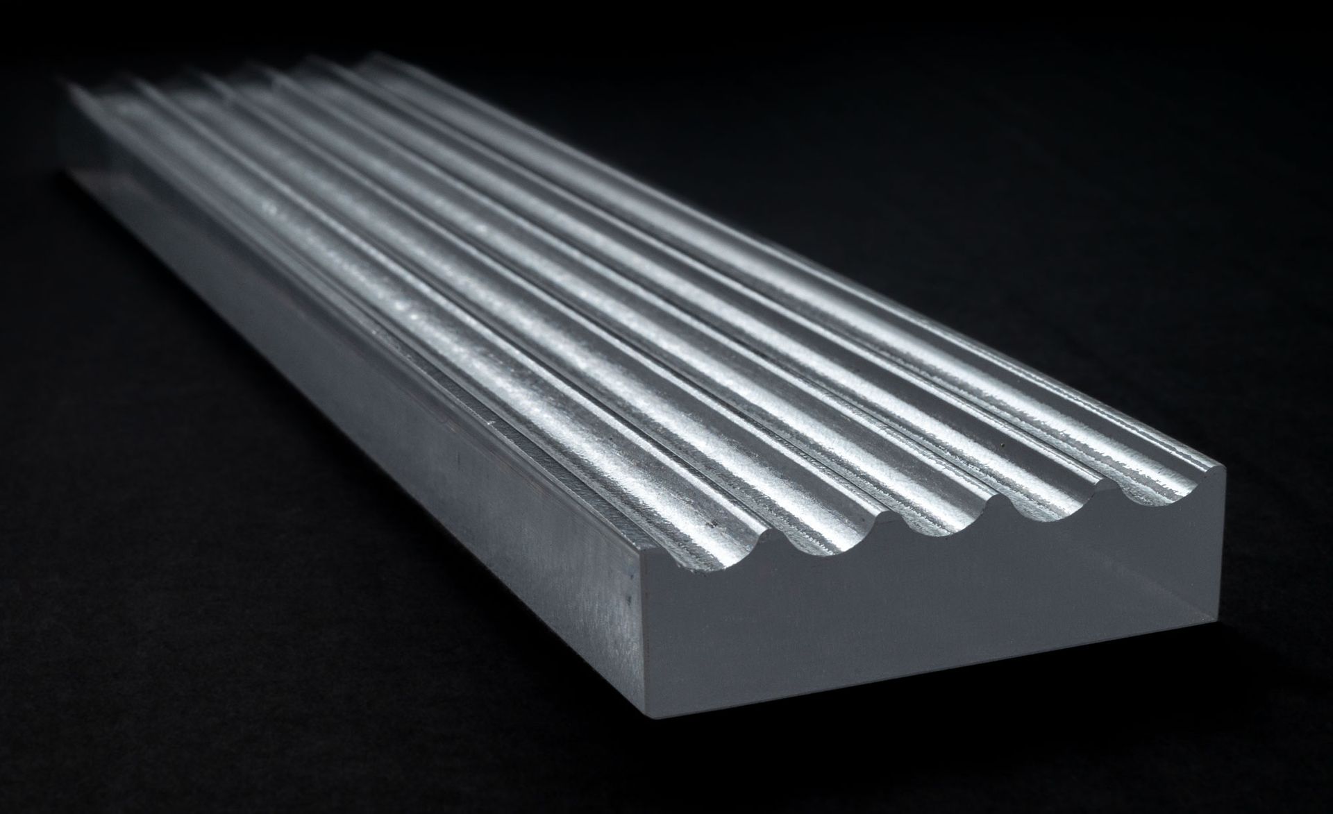 A close up of a piece of metal on a black surface.