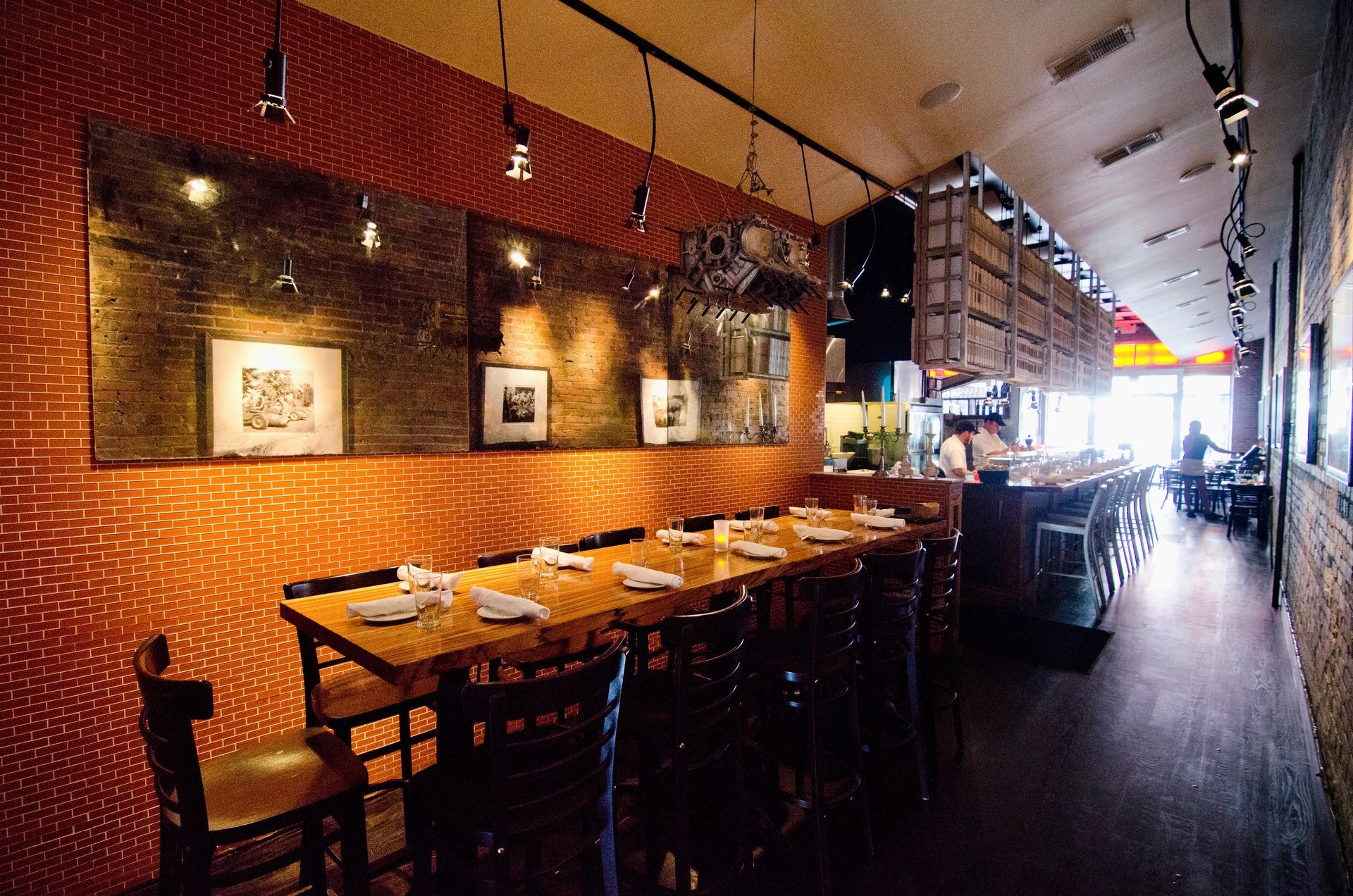 A restaurant with tables and chairs and a brick wall with antique mirror