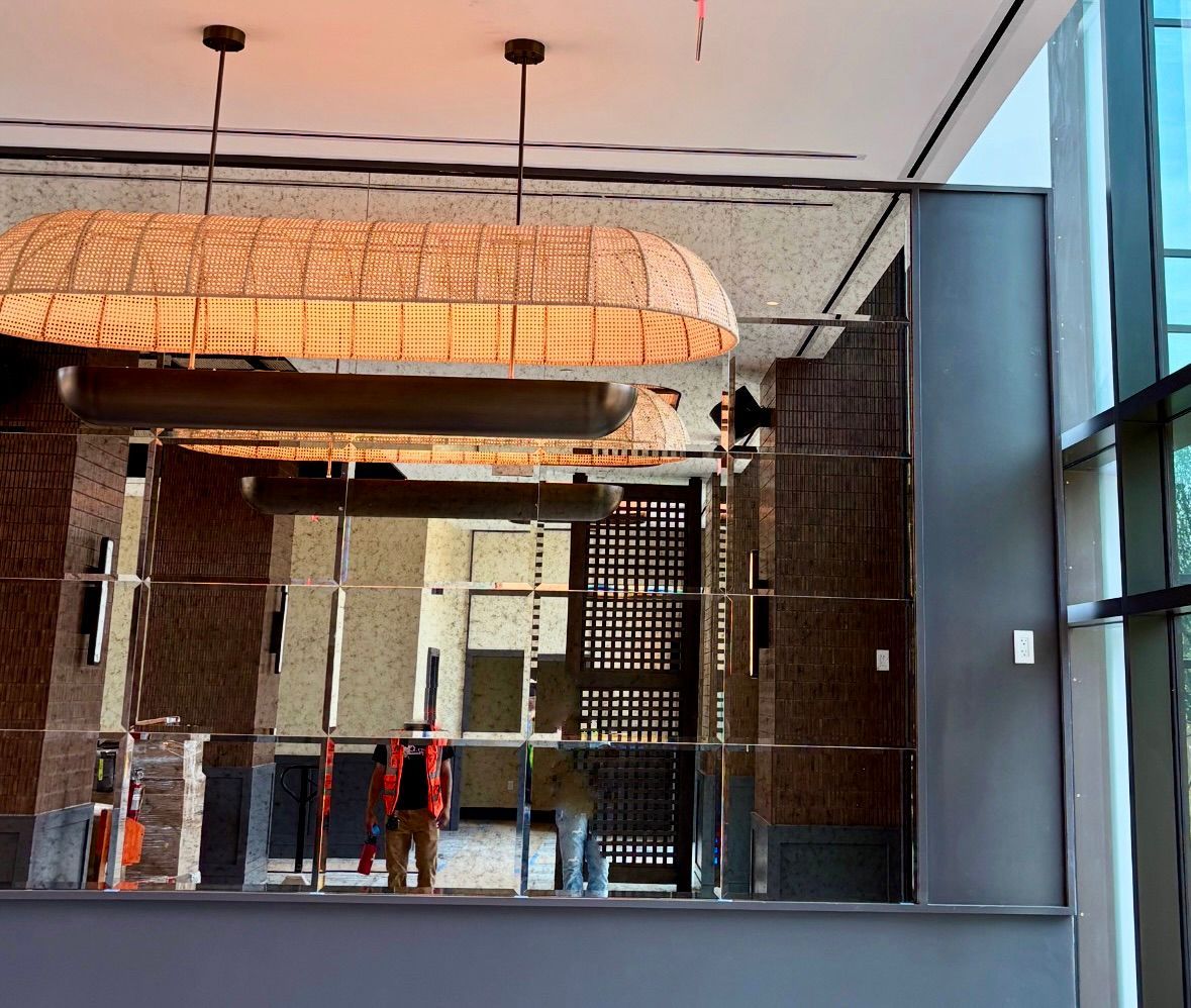 A modern interior with an antique mirror wall, revealing a view of an adjacent room.
