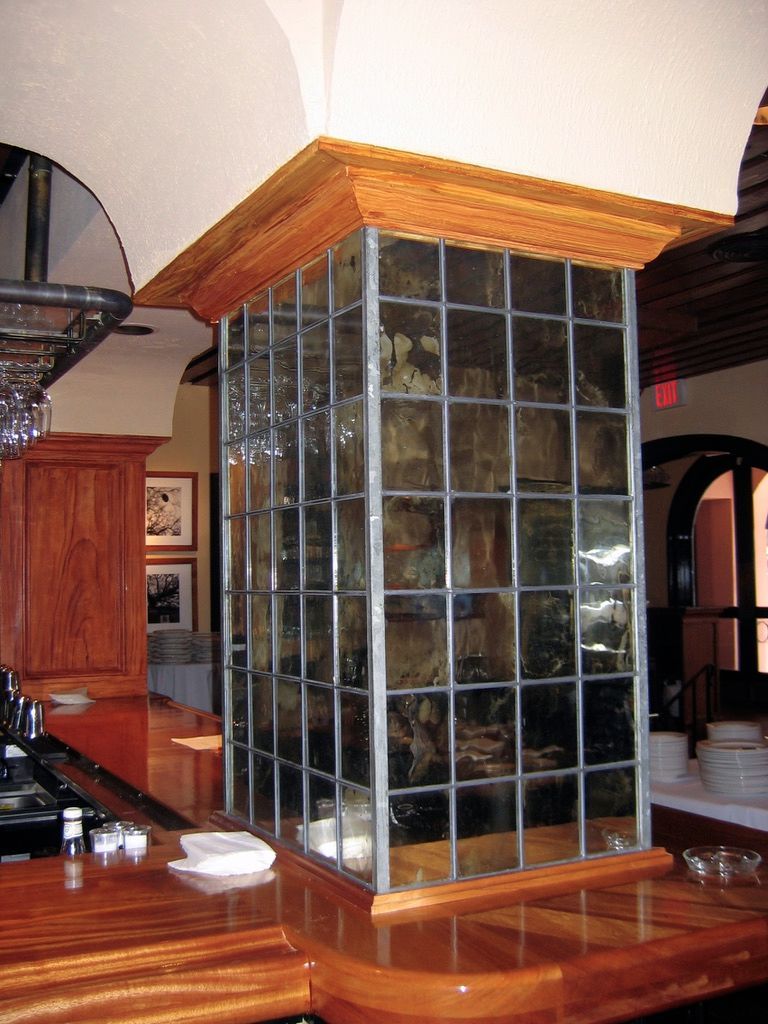 A corner of a kitchen with a stained glass window