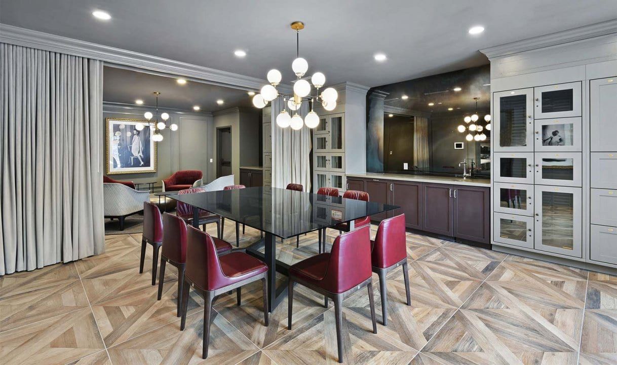 A large dining room with a long table and red chairs.