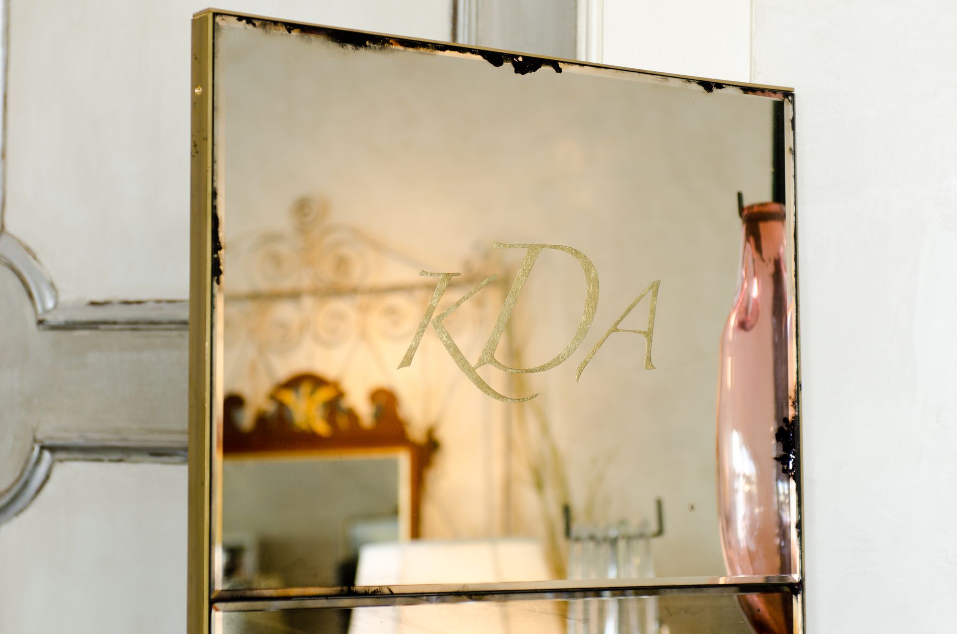 An antique mirror with the letters kda on it