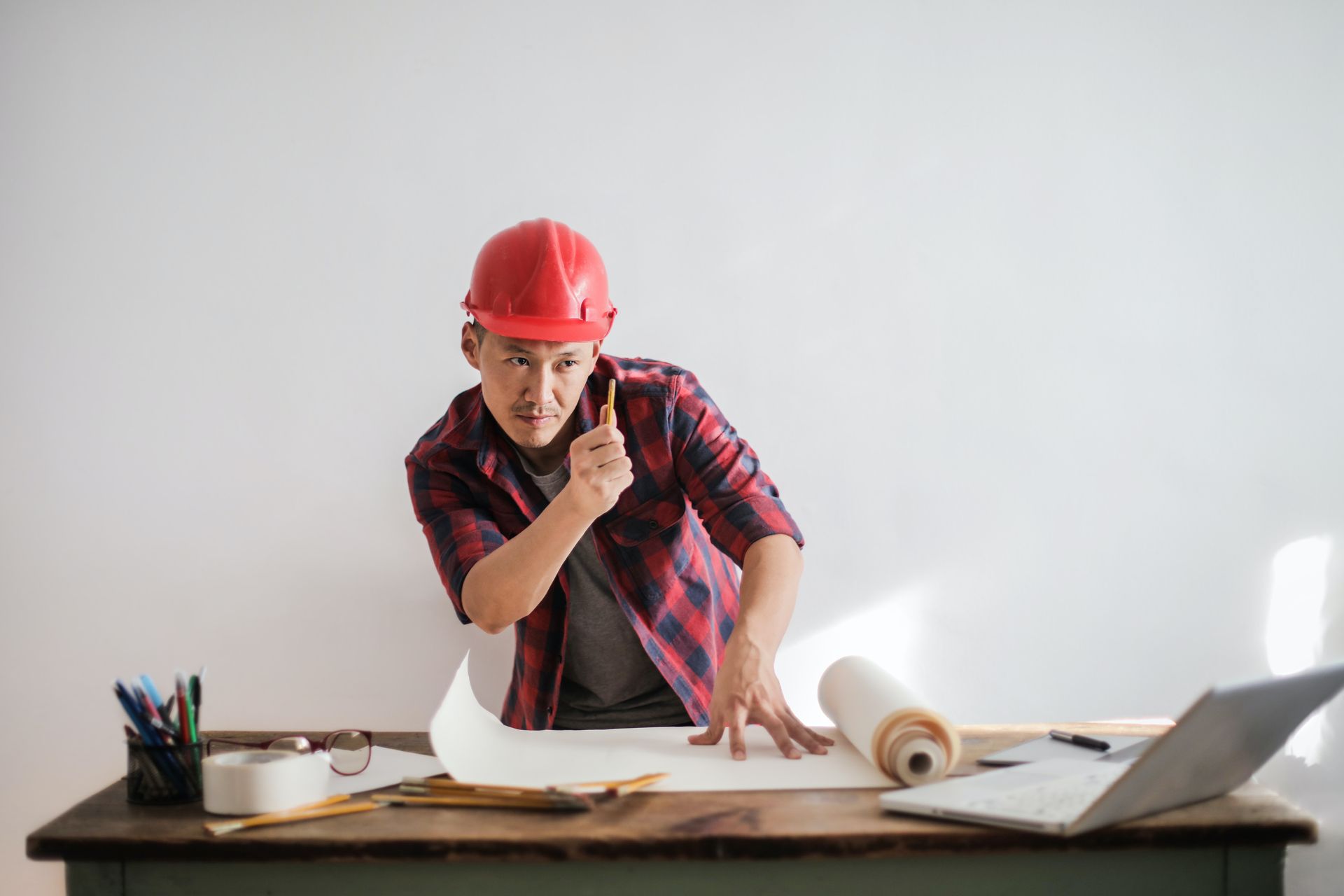 An architect working over the blueprints of a glass flooring project.
