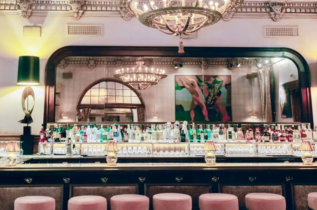 A bar filled with lots of bottles of liquor and stools.