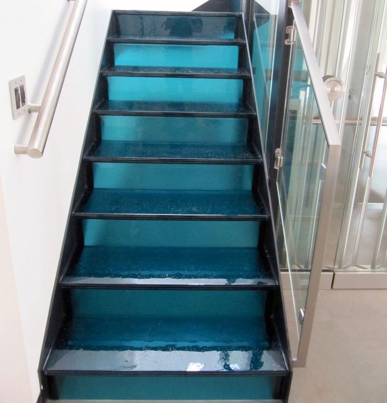 A glass staircase with blue steps and a stainless steel railing