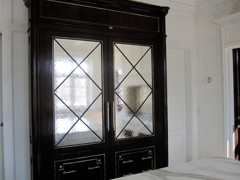 A black cabinet with a antique mirrored glass door
