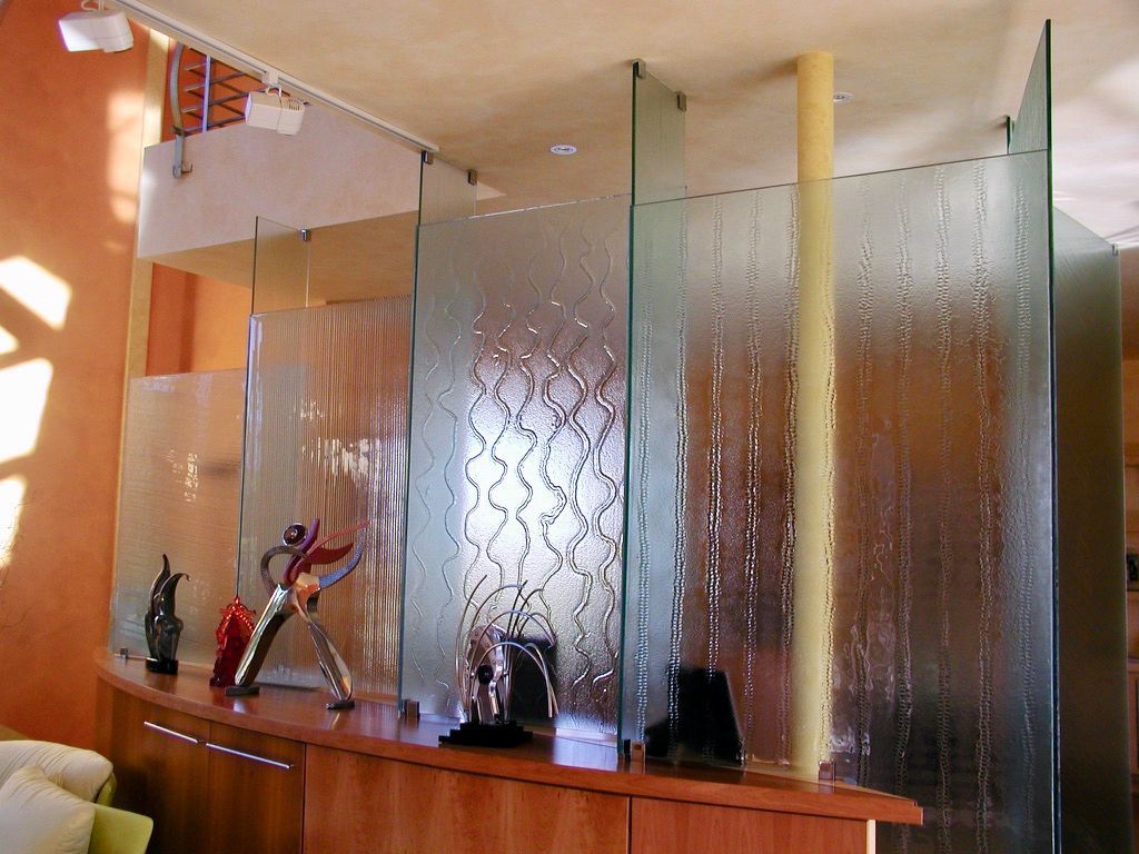 Glass room dividers in modern office setting. Display cabinet with artwork, tan and brown tones.