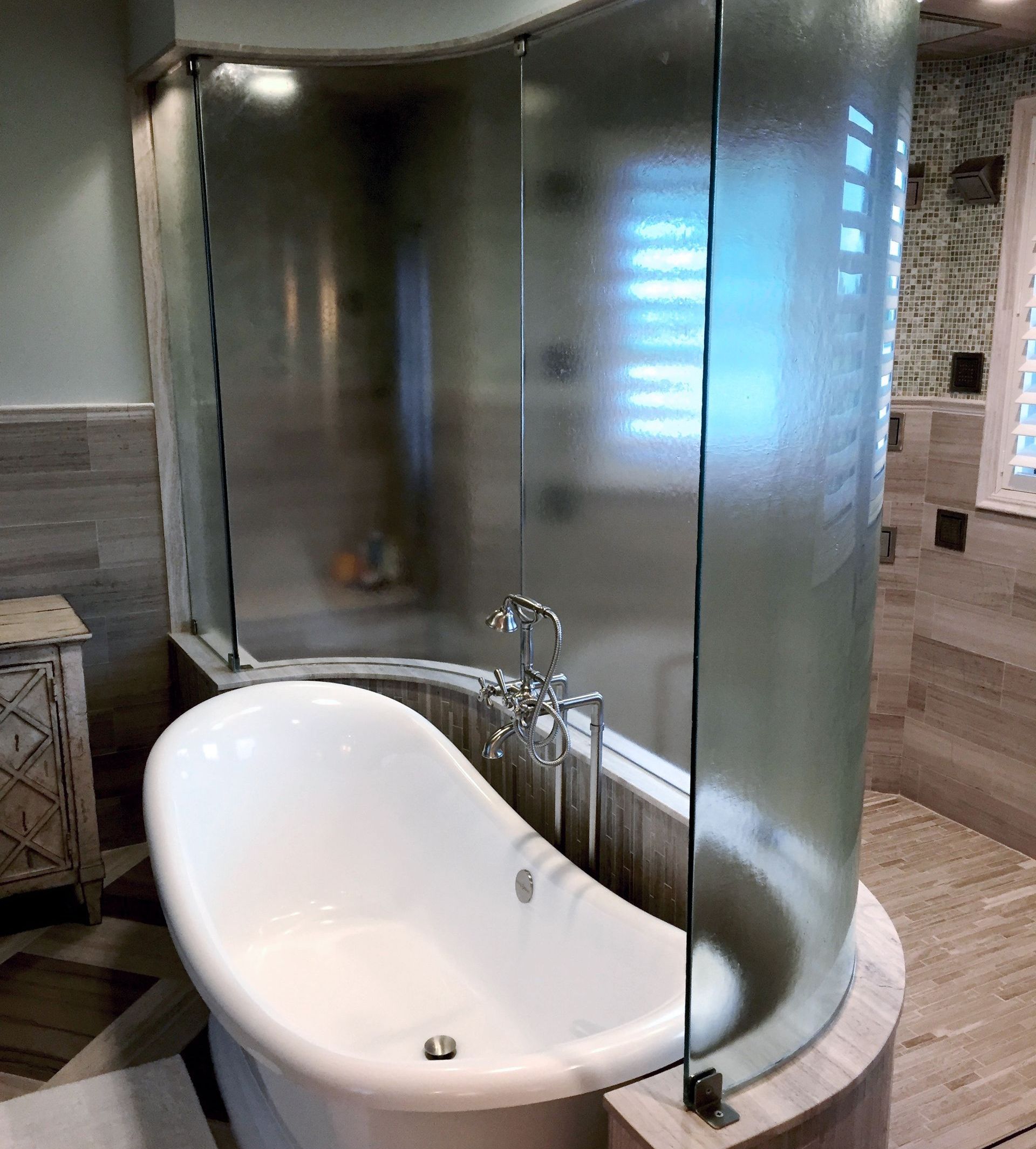 A bathroom with a bathtub and a glass shower stall.