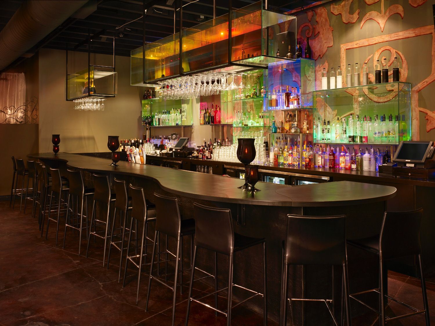 A long bar in a restaurant with a lot of alcohol on it