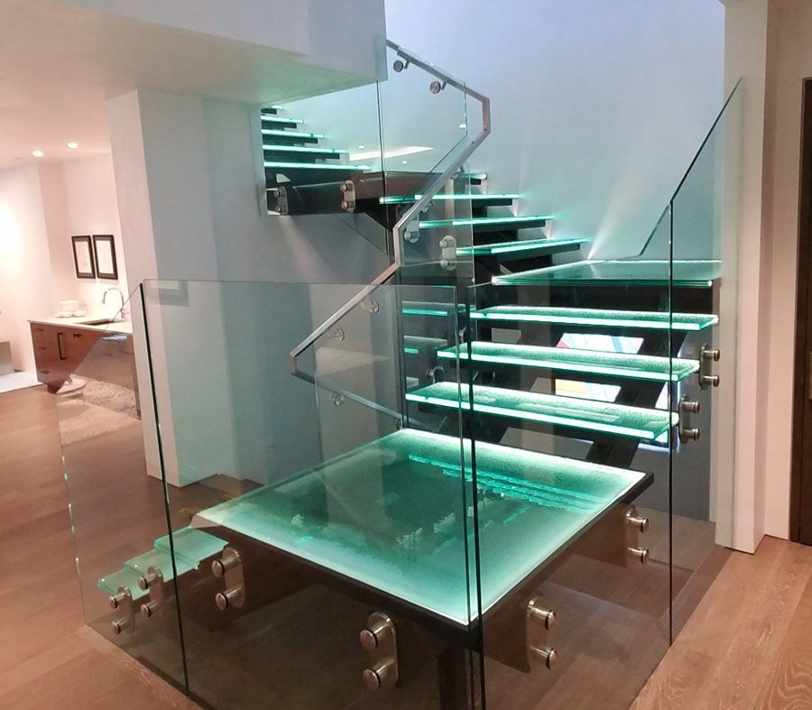 A glass staircase with a glass railing and steps in a house.