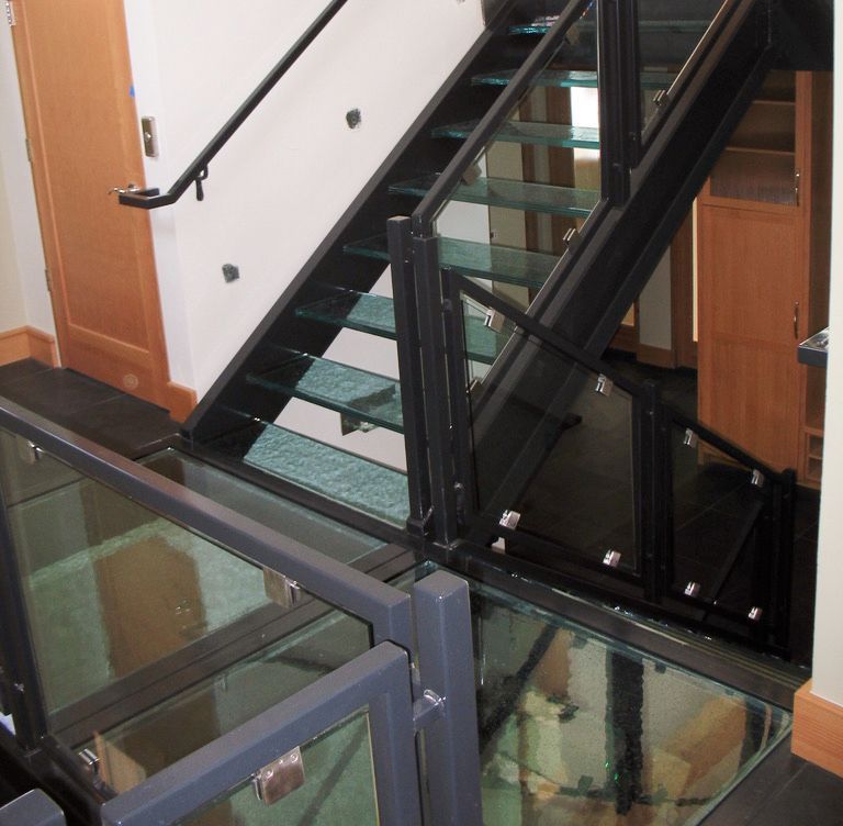 A staircase with glass steps and a black railing
