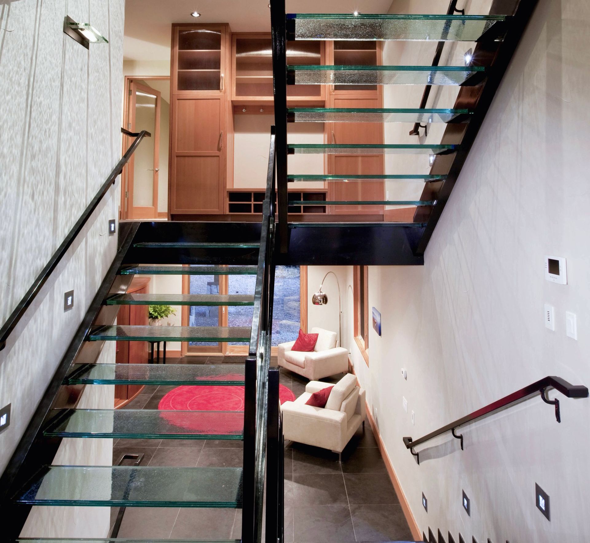 A glass staircase leading up to the second floor of a house