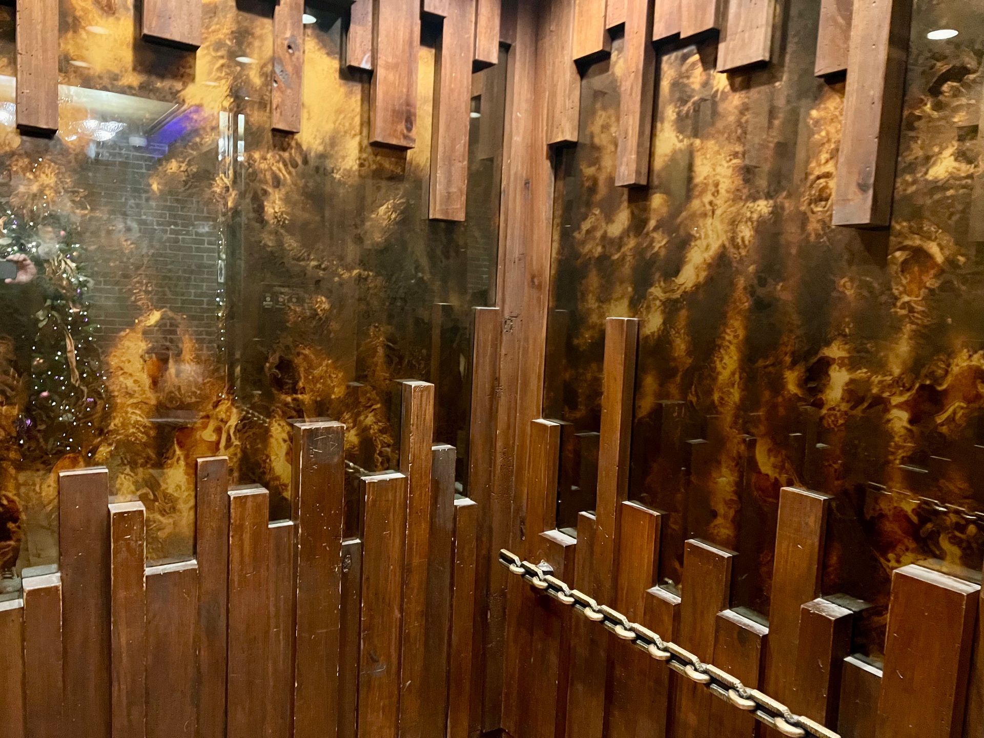A wooden wall with a decorative antique mirror in an elevator.