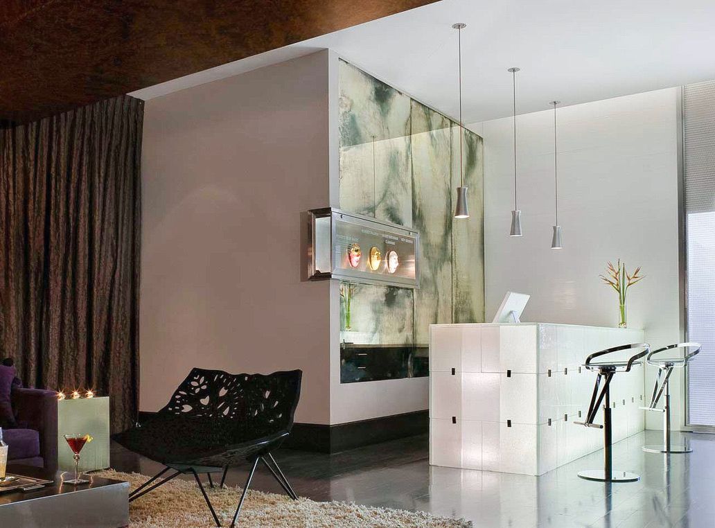 A living room with a couch , table , chairs and a counter featuring antique mirror