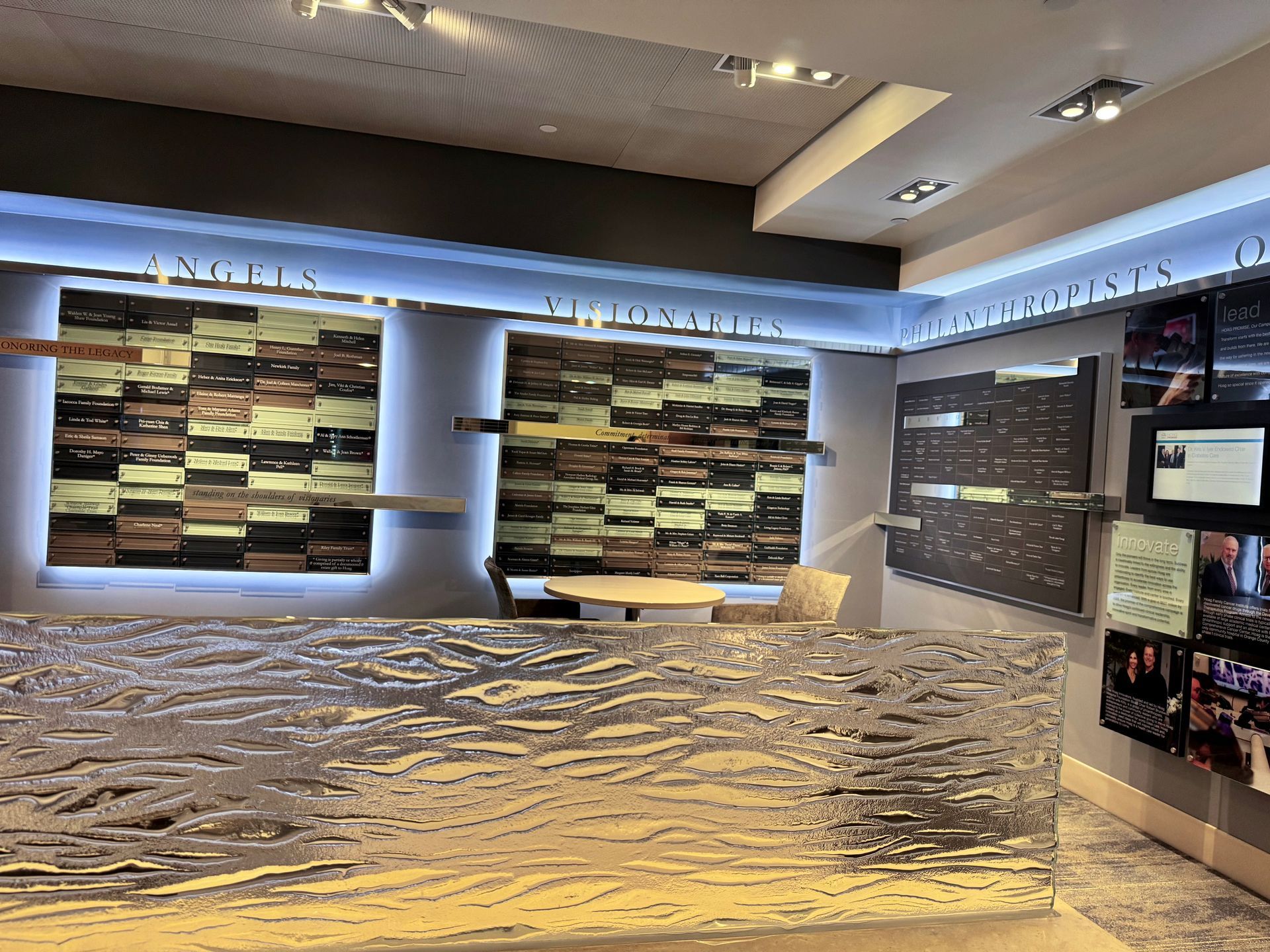 An exhibit hall with tiled wall displays and a shiny metallic counter.