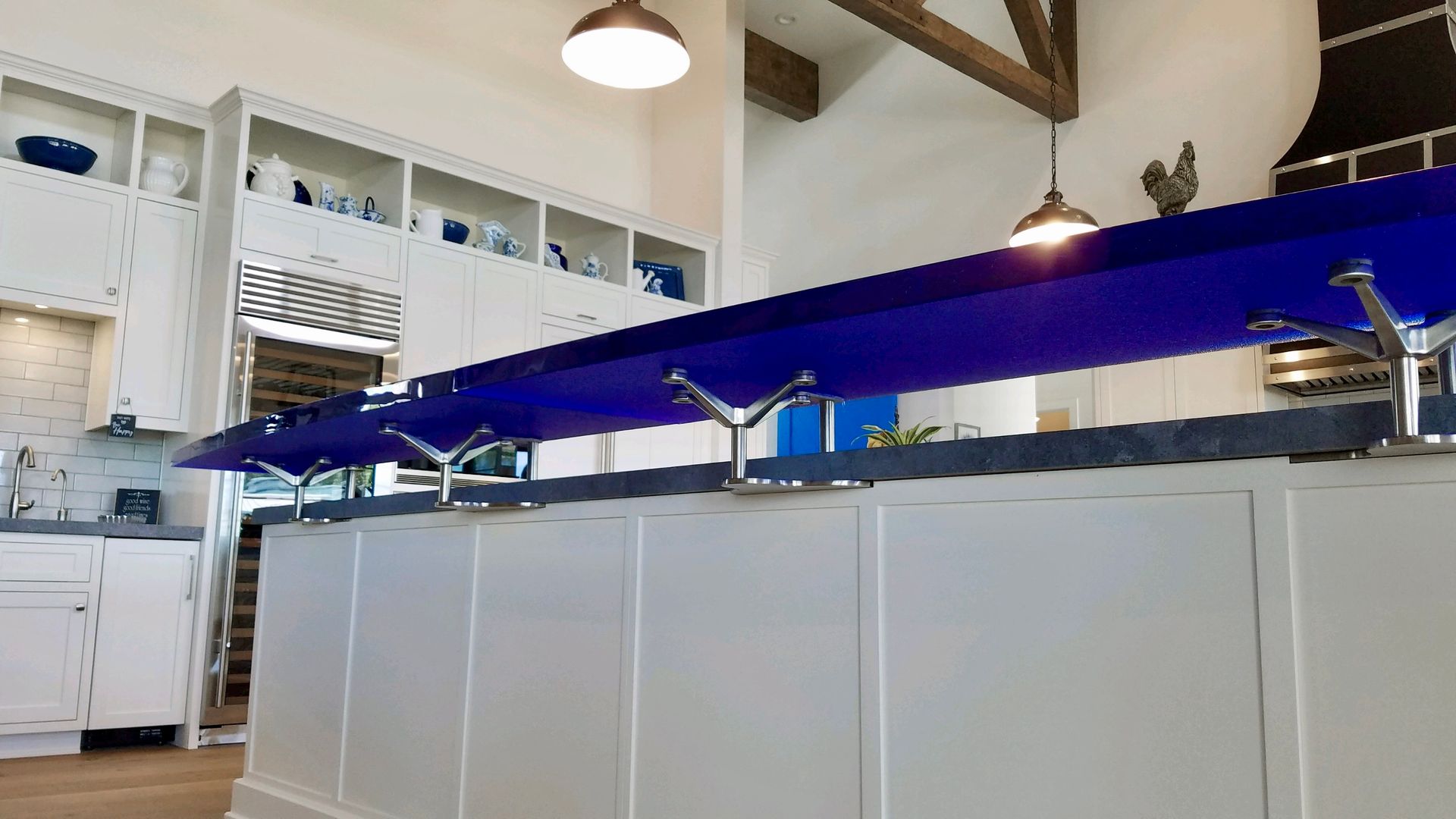 A kitchen with a blue counter top and white cabinets.