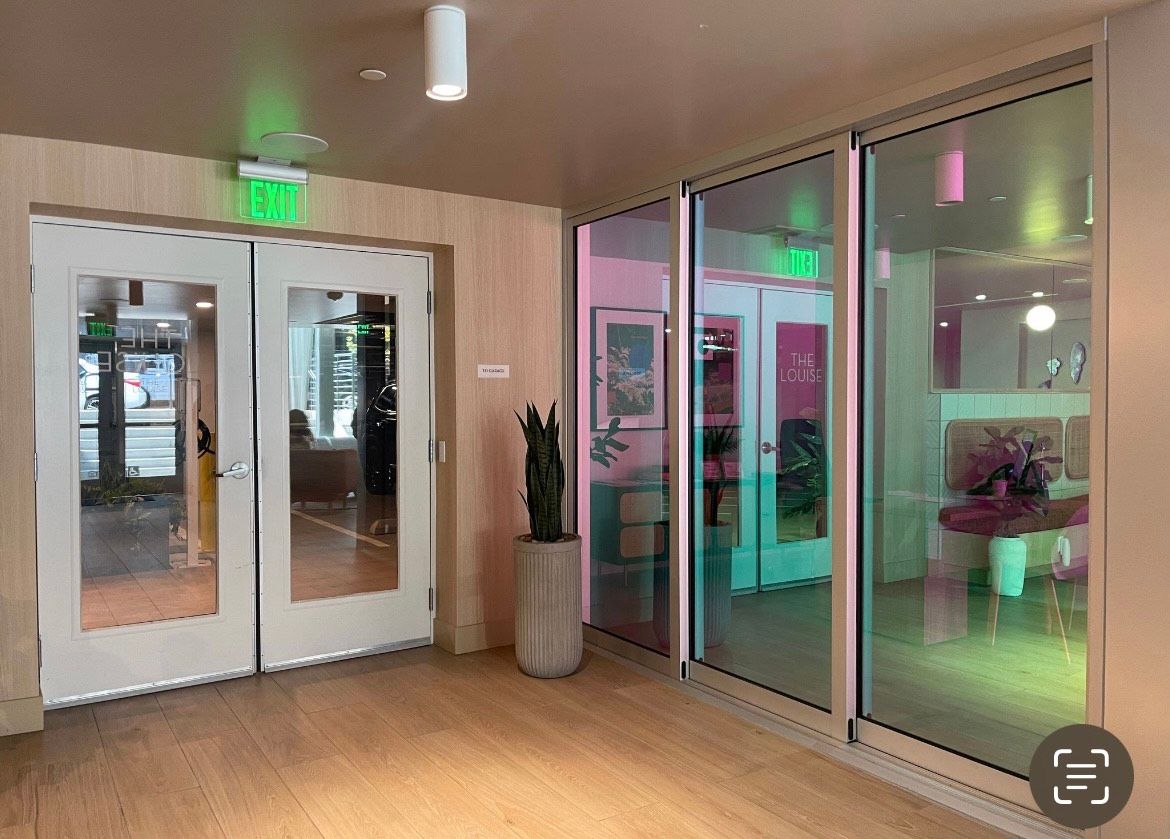 A hallway with a green exit sign on the ceiling