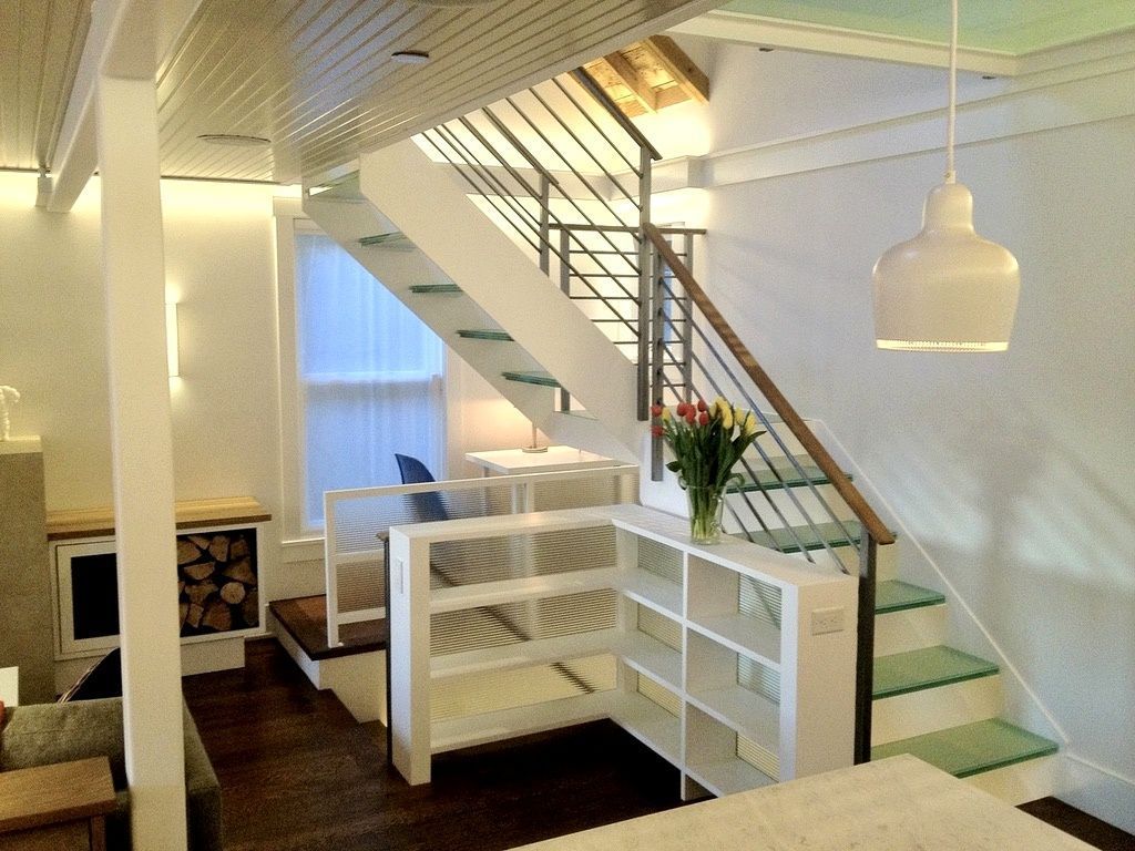 Interior with white staircase, shelving, fireplace, and hanging light.