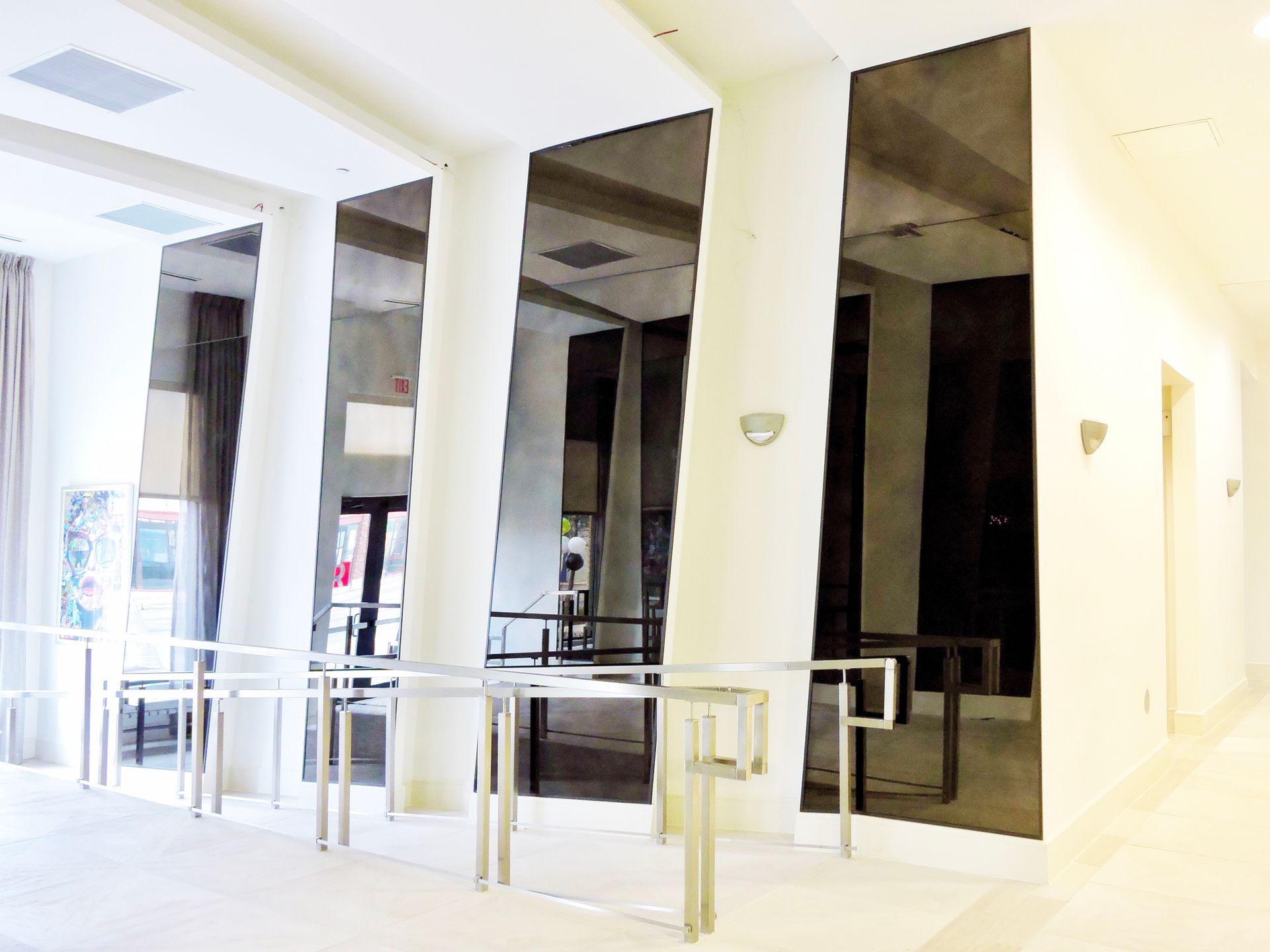 A hallway with columns and antique mirrors on the walls