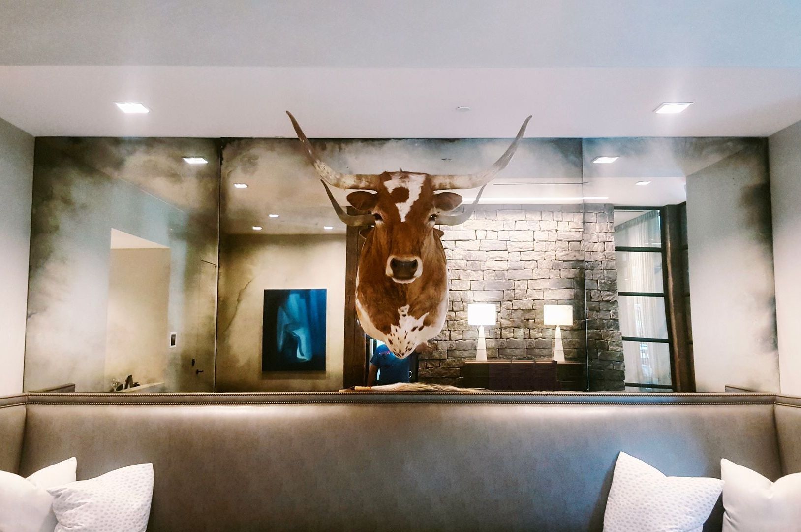 A painting of a cow 's head is hanging on a wall in a living room.