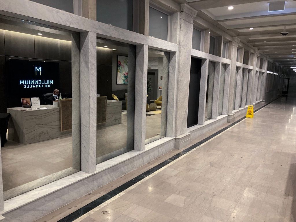 A long hallway with antique mirrors and a yellow wet floor sign