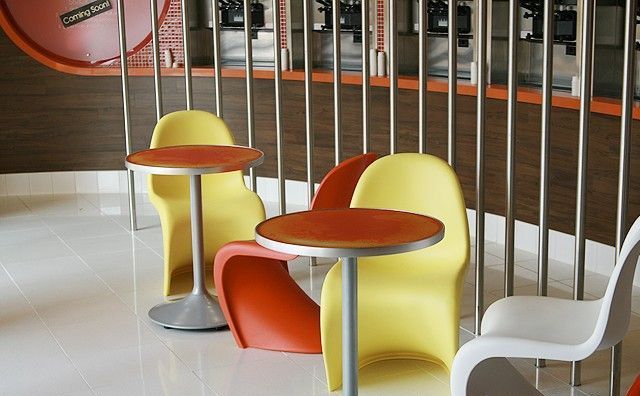 A row of colorful chairs and tables in a restaurant