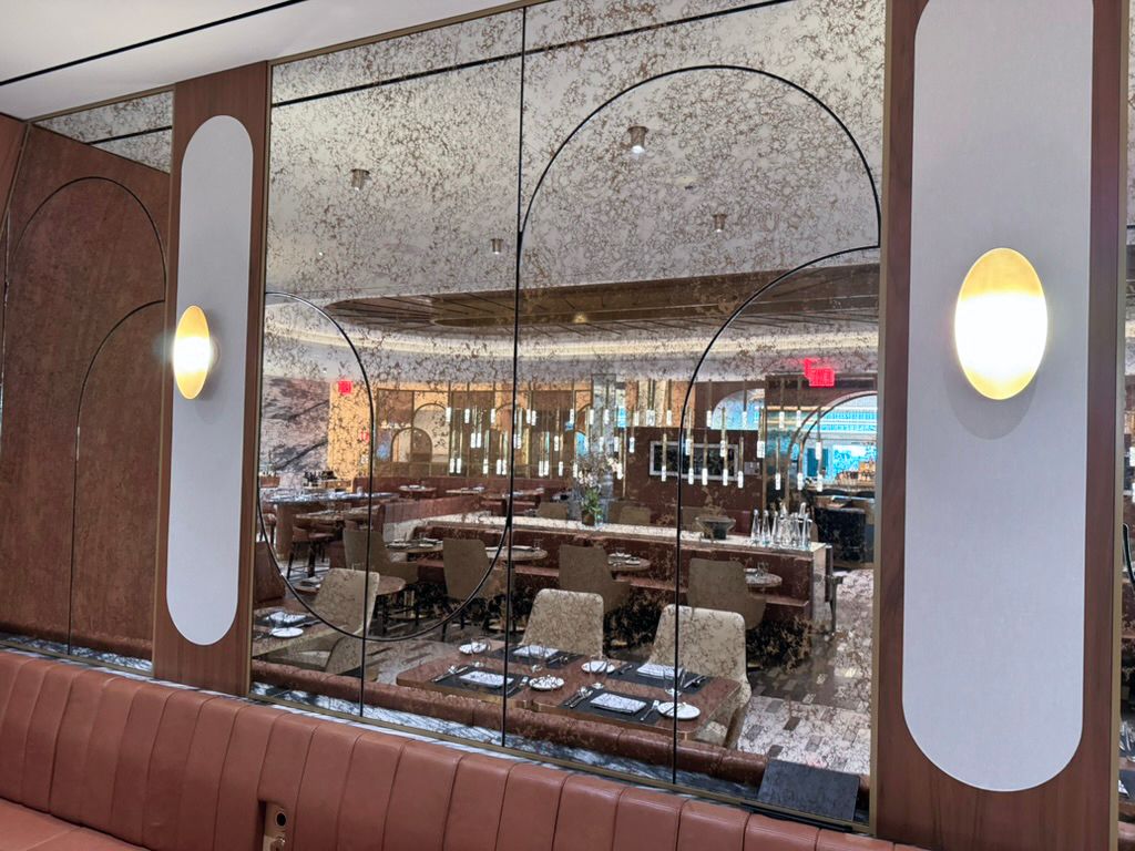 Restaurant interior with booths, large windows, and a long table set for dining.