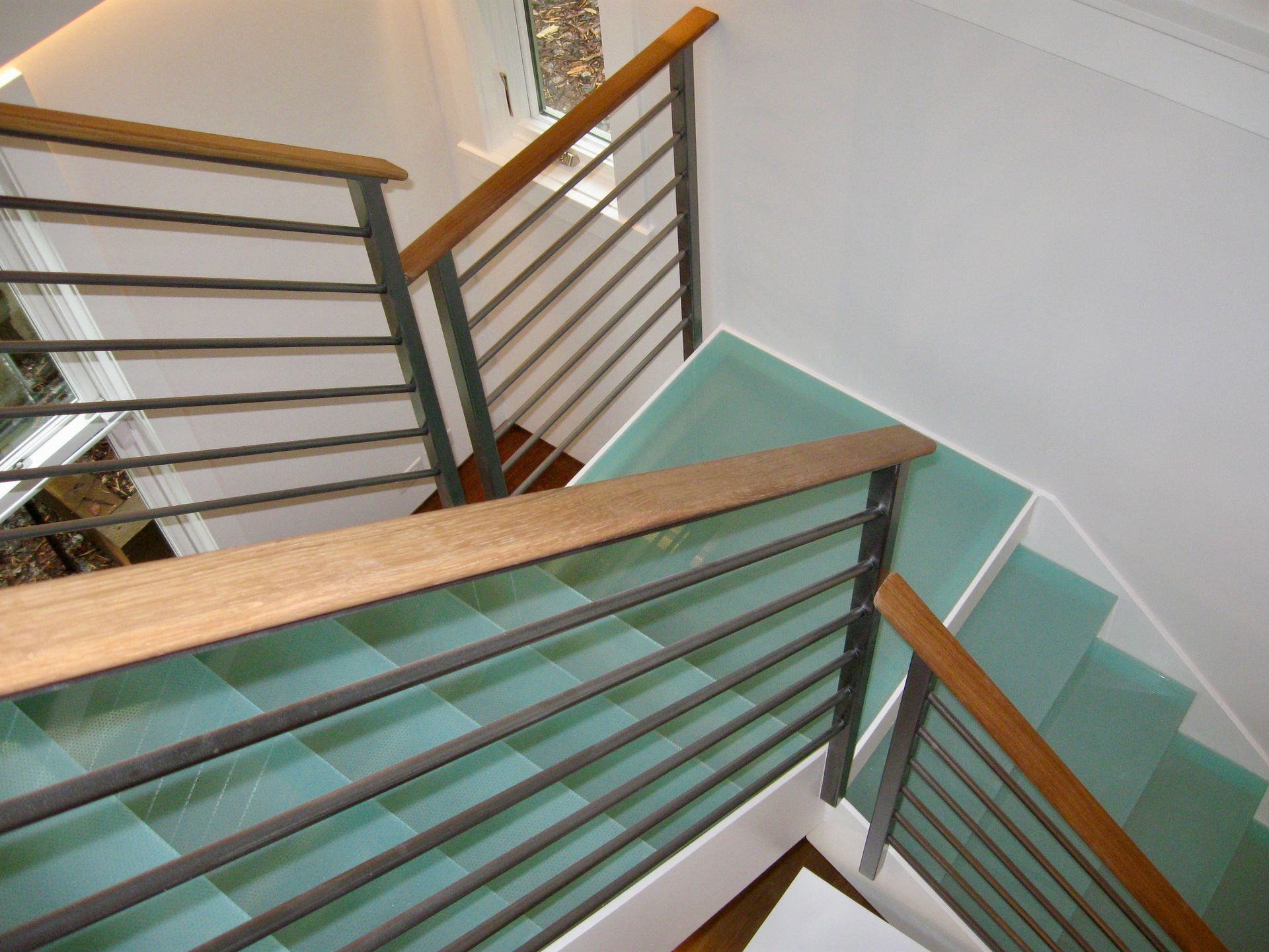 A picture of a glass staircase taken from the top of the stairs looking down the glass treads.