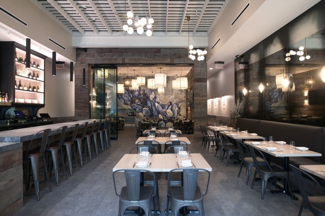 A restaurant with tables and chairs and a antique mirror on the wall