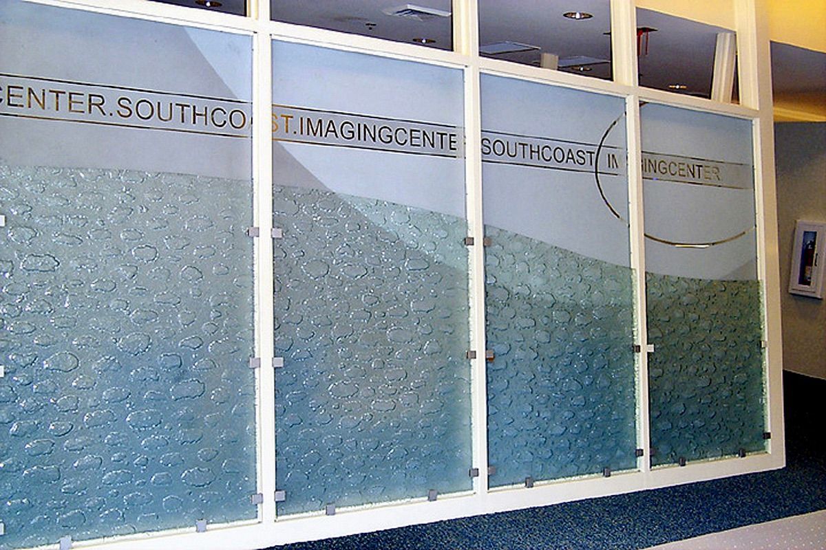 Glass wall with a gradient of blue pieces. Text across the top reads
