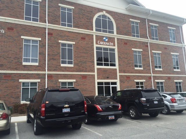 Cars are parked in front of a large brick building that says canals