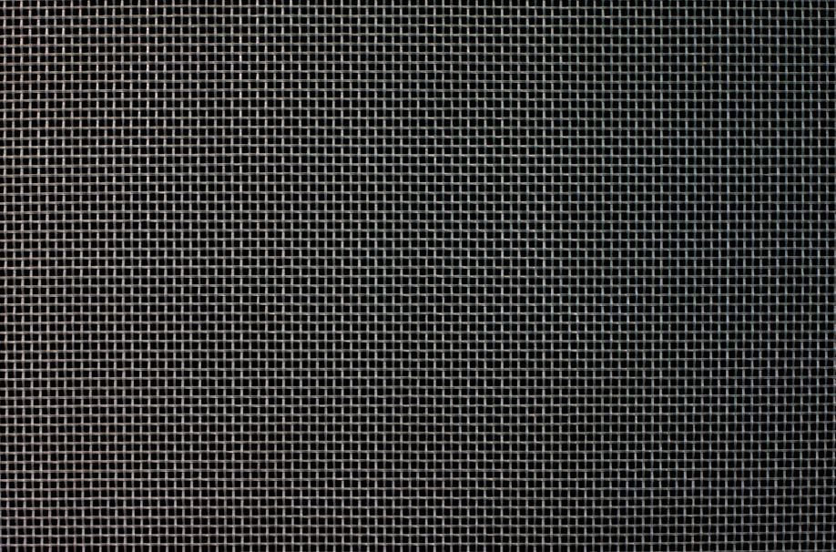 Close-up of a metal grid with a fine, square mesh pattern, in shades of gray.