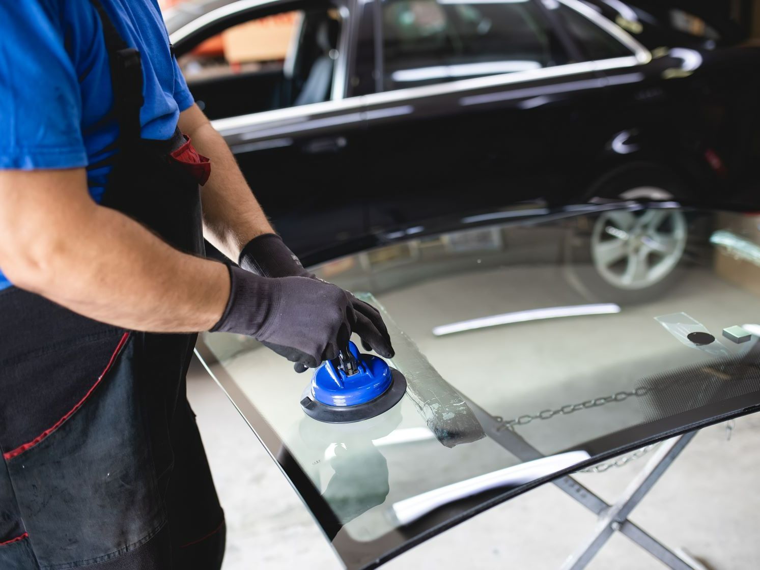 A man is installing a windshield on a car.