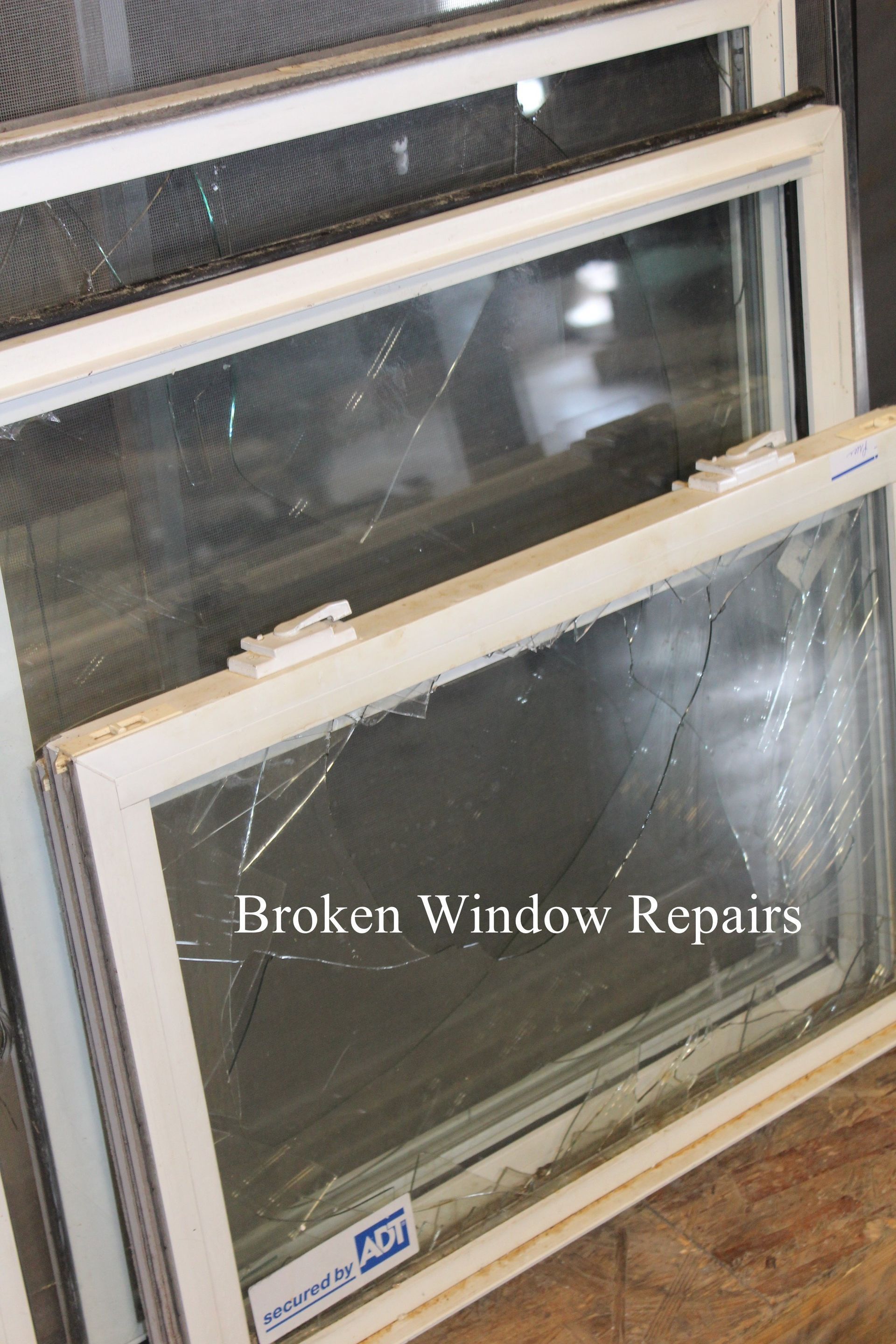 A broken window is sitting on top of a wooden table.