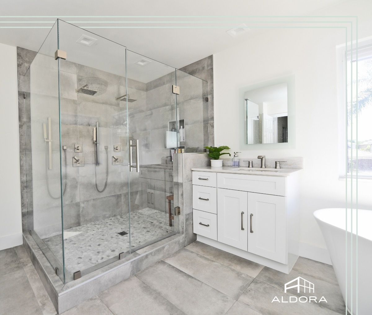 A bathroom with a walk in shower , sink , mirror and tub.