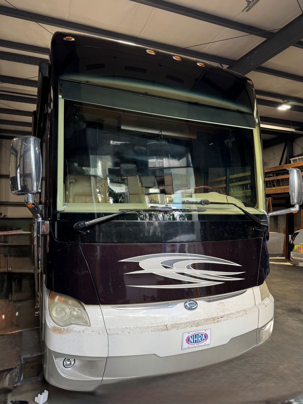 A large rv is parked in a garage.