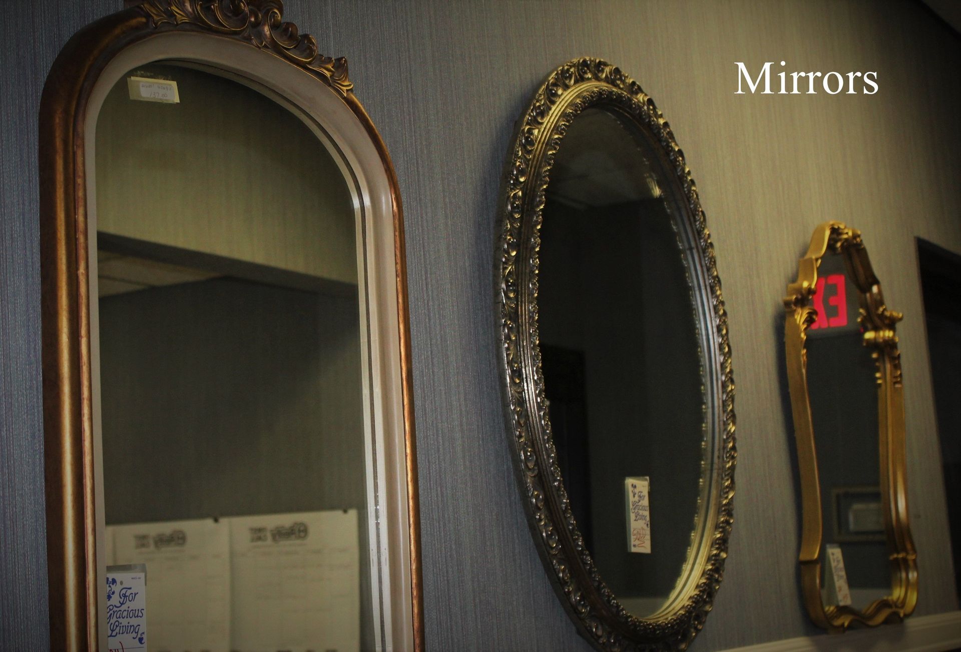 A row of mirrors on a wall with the word mirrors above them
