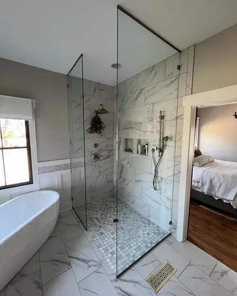 A bathroom with a walk in shower and a bathtub.