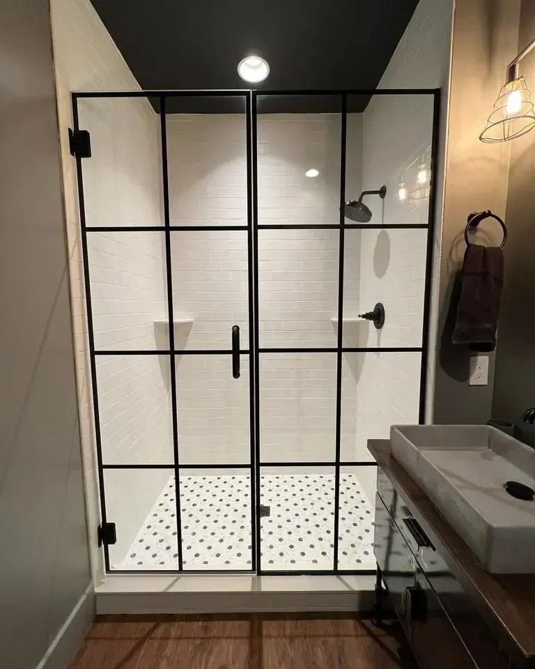 A bathroom with a walk in shower and a sink
